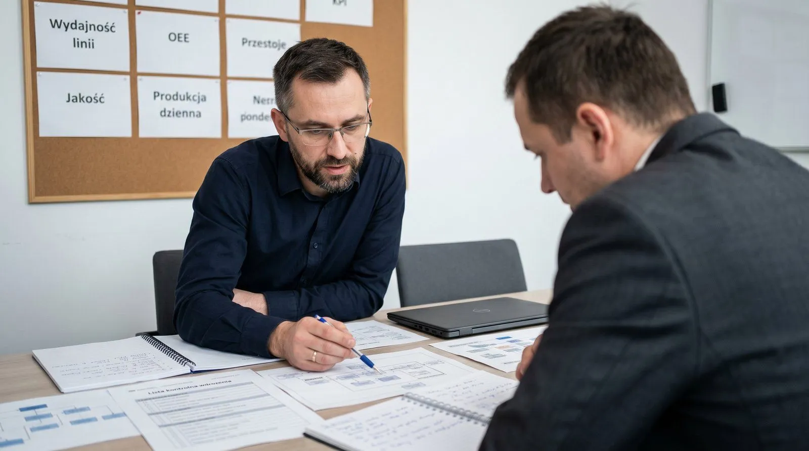 Konsultanci ERP analizujący dashboard wdrożenia u klienta produkcyjnego