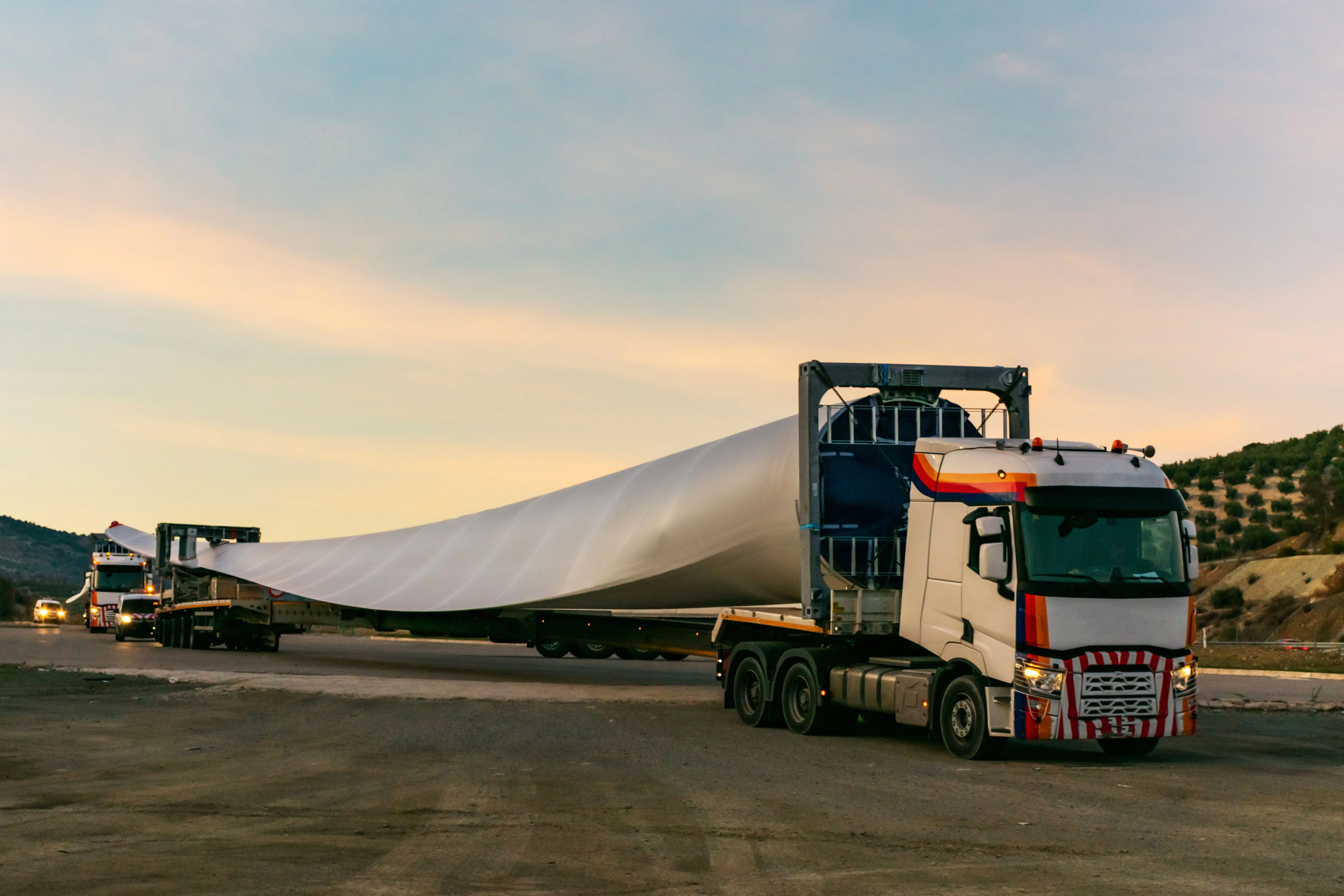 Transport ponadgabarytowy - ciężarówka przewozi łopatę turbiny wiatrowej na naczepie lowboy